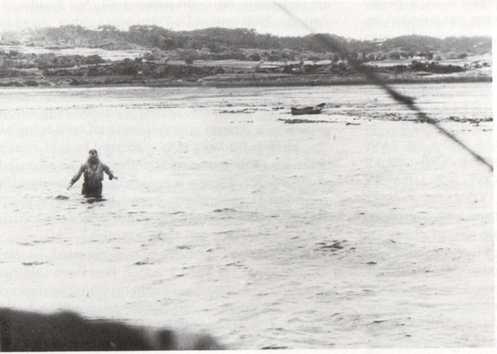 Lieutenant Fox wading towards his rescue aircraft on 29 March 1945.