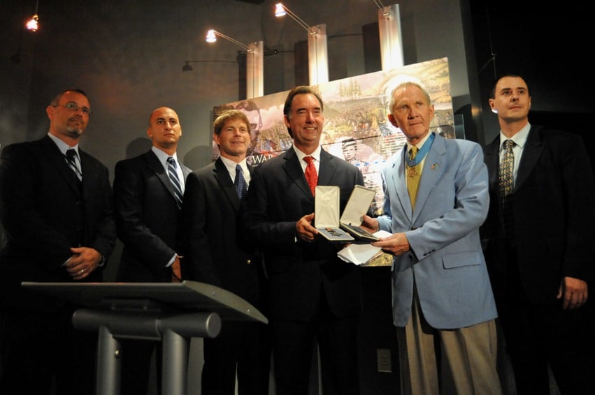 Maj. Gen. James Livingston accepts returned medals from FBI agents.