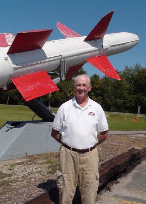 Volunteer Larry Moran in front of a Talos missile.