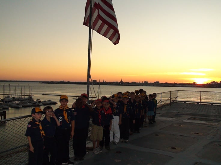 Cubs under the national flag as the sun sets on historic Charleston.