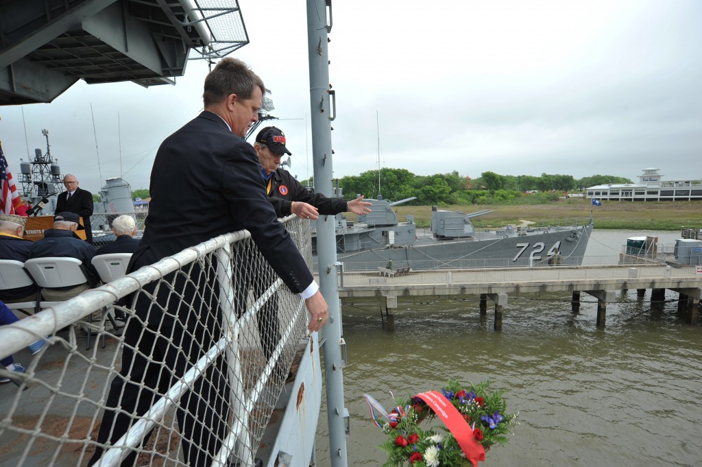 Rep. James E. Smith assists Dick Whitaker in tossing a wreath into the water in memory of the ground forces at the Battle of Okinawa