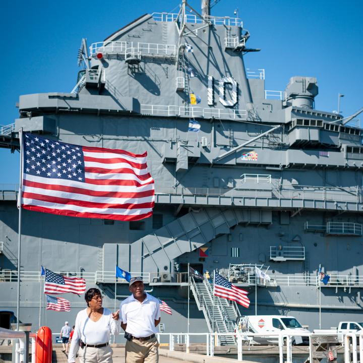 Man and woman walking away from the USS Yorktown