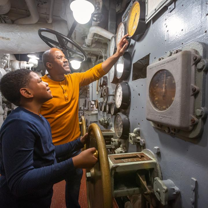 Father and son look at the internal systems on the USS Yorktown.