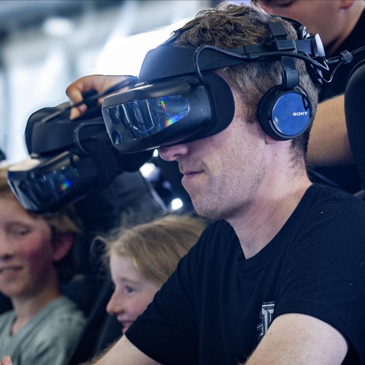 Man and two children get strapped in with a VR headset.