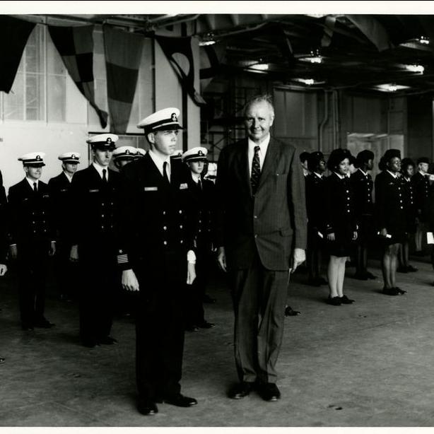 This photograph shows a Secretary of the Navy William Middendorf posing beside Navy Men and Women on deck for opening day ceremonies aboard the USS Yorktown, January 3, 1976.