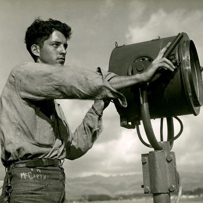 Thomas McCarthy stands on deck and operates a signal light.