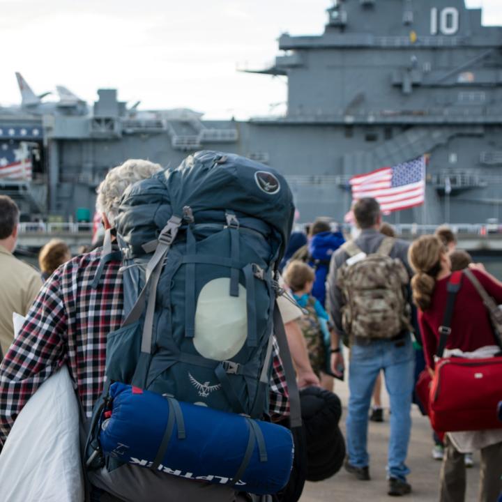People carrying on backpacks and overnight bags for Operation Overnight