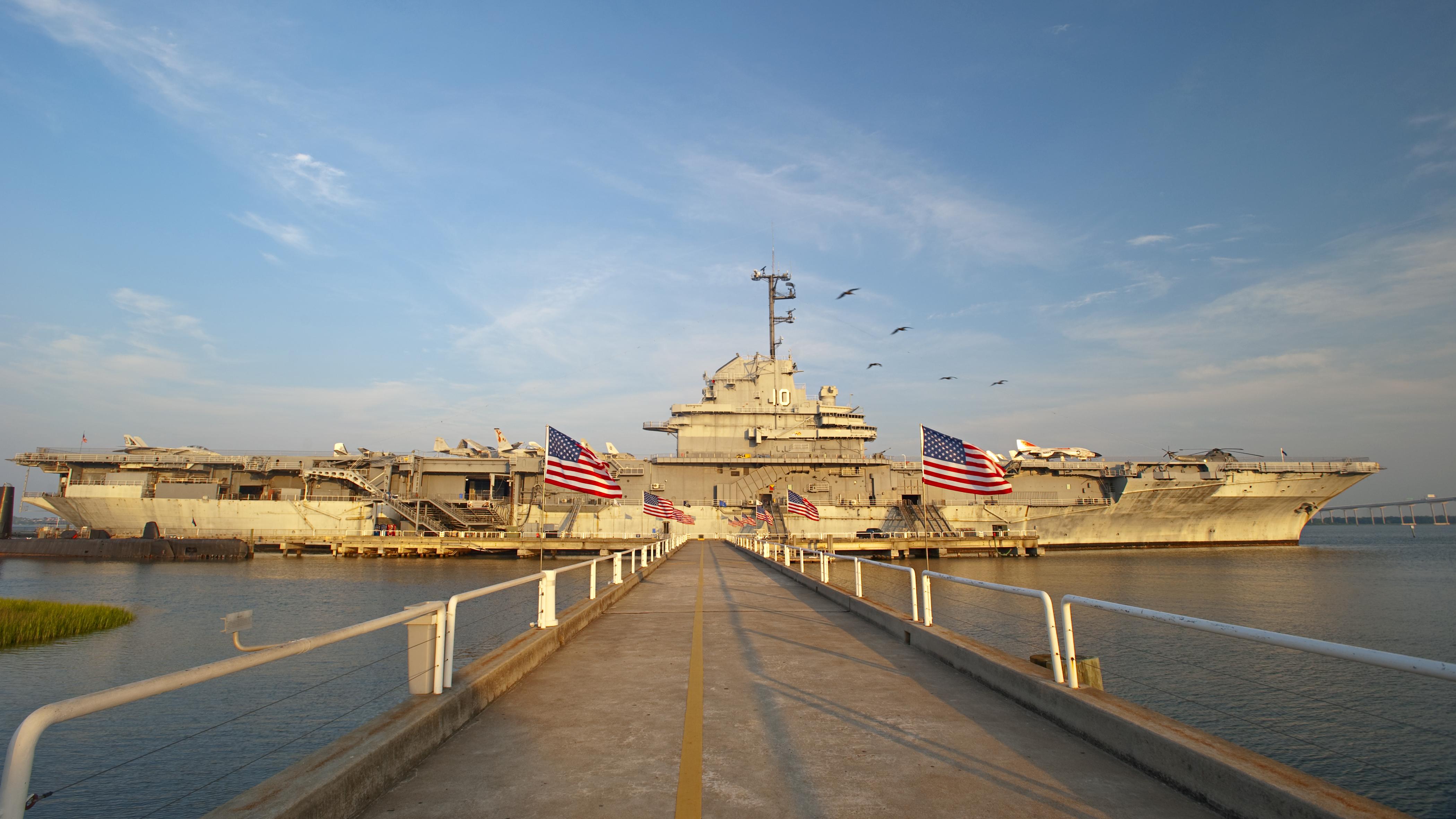 Walkway leading to the USS Yorktown aircraft carrier at Patriots Point, adorned with American flags on both sides.