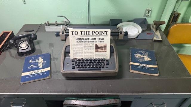 The 'To The Point' newsletter sits on top of the typewriter on the captain's desk.