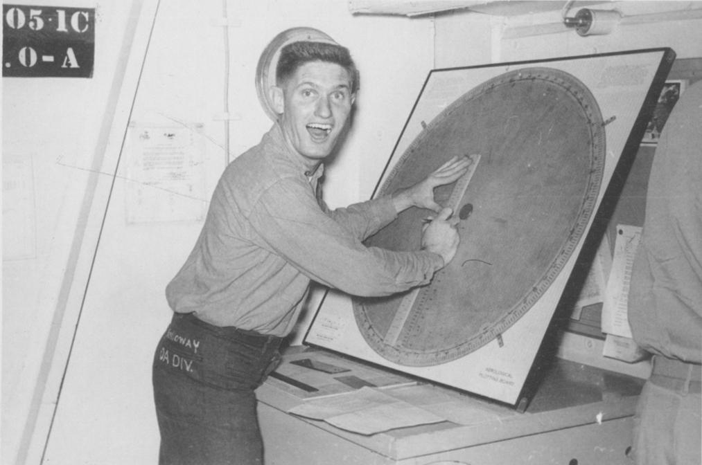 Black and white snapshot of a member of the crew of USS YORKTOWN plotting the winds aloft during Korea.