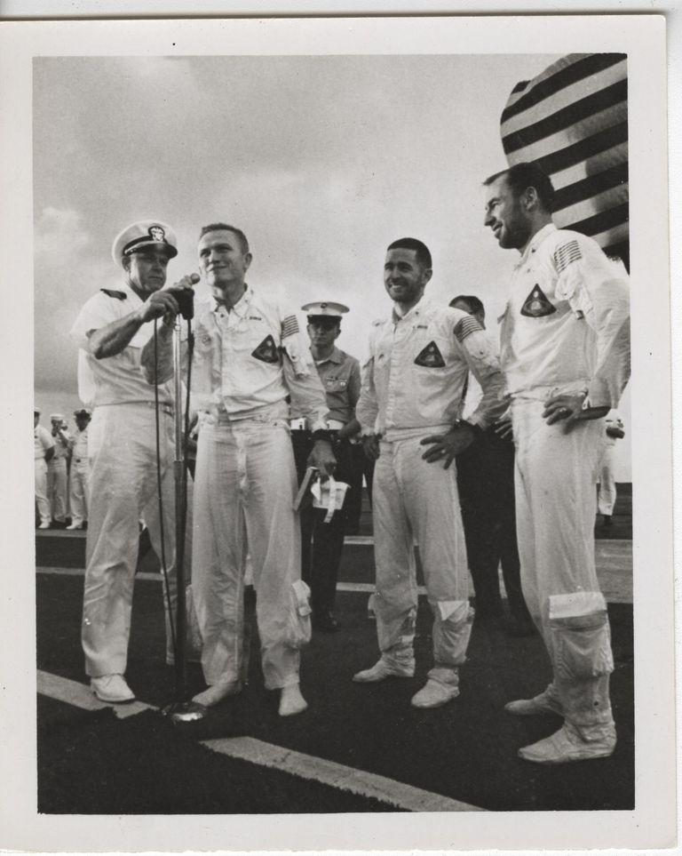 The Apollo 8 astronauts addressing the crew and the media following the recovery of the Apollo 8 capsule. Captain John Fifield holds the microphone for Frank Borman. 