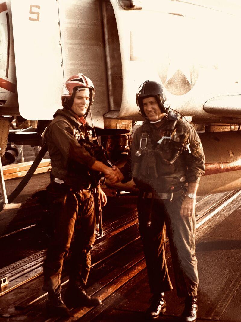 Seamus and Admiral Flatley shaking hands in front of an aircraft